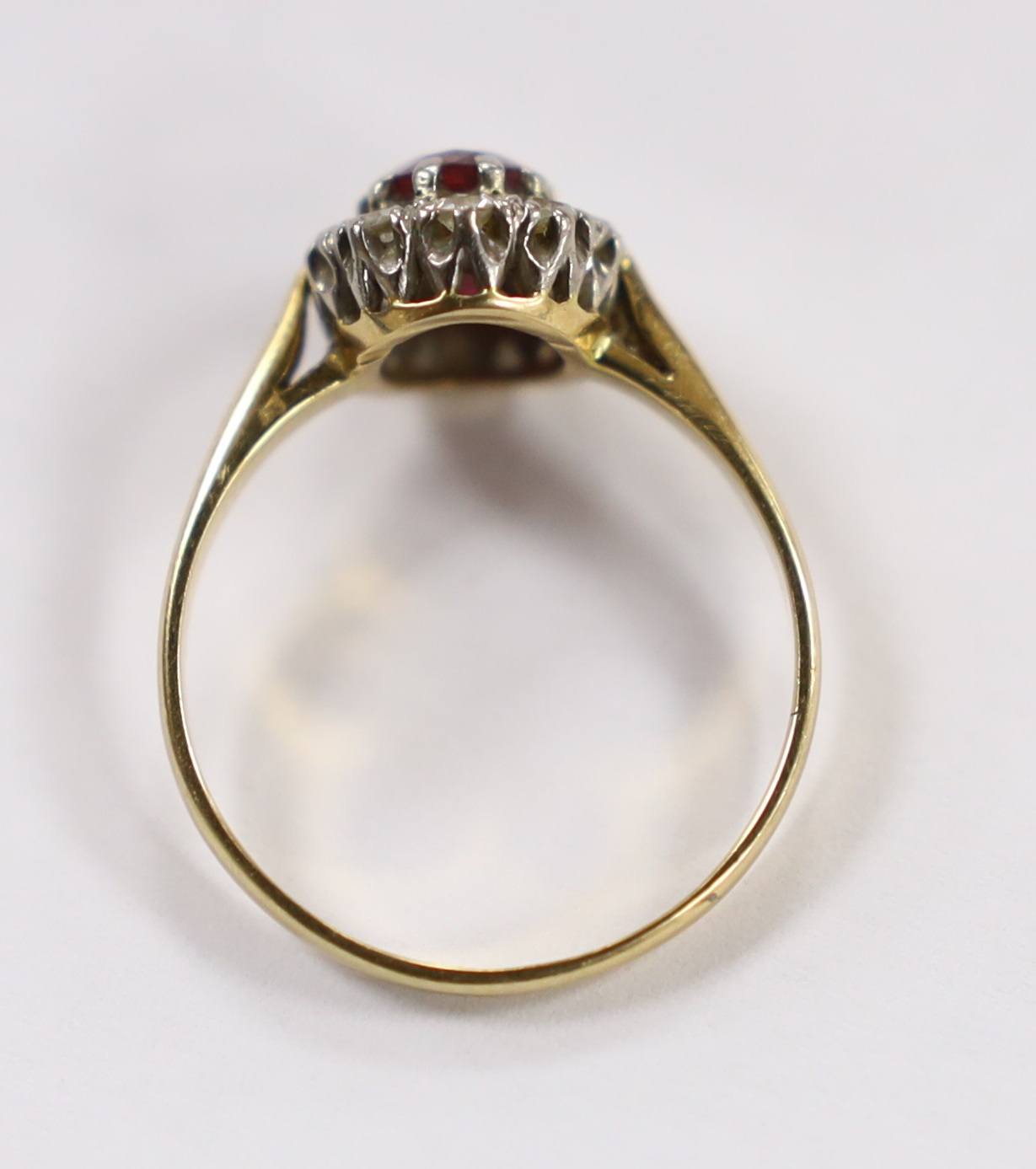 An 18ct, ruby and diamond set oval cluster ring, size N/O, gross weight 2.5 grams.